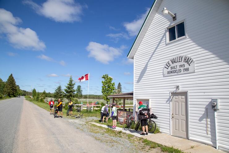 Cyclists in front of Lee Valley Hall, a historic building 